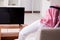 The arab man watching tv at home