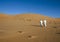 Arab men with turban, desert tour guides walking in desert