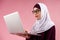 Arab smart woman in hijab type text on a laptop.