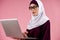 Arab smart woman in hijab type text on a laptop. Female writer concept