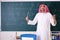 The arab teacher in front of chalkboard