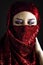 Arab young with traditional red veil, eyes intense, mystical beauty