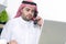 Arabian Businessman using Laptop and talking on phone