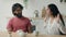 Arabian Indian couple in kitchen with coffee sharing news multiracial diverse woman wife and man husband talking
