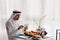 Arabian Male Using Tablet During Breakfast