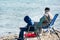 An Arabian man and a boy fishing at the beach at the corniche park, Dammam, Saudi Arabia