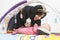 Arabian Mother feeding her baby girl on a play mat