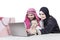 Arabian parents and child looking laptop