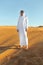 Arabian sheikh in long white dress closeup in the middle of Dubai desert