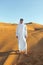 Arabian sheikh in long white dress closeup in the middle of Dubai desert