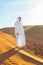 Arabian sheikh in long white dress closeup in the middle of Dubai desert