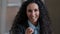 Arabian smiling curly woman employee business lady pointing index finger at camera emotionally speaking explaining