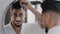 Arabian spaniard arab man looking at mirror combing hair with hairbrush getting ready in bathroom home guy morning