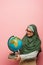 arabian teacher in green hijab holding