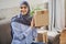 Arabian woman holding cardboard boxes and giving a smile to the camera