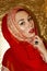 Arabian young woman. Gold make-up. Red ethnic clothes shawl hijab, accessories.