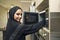 Arabian young woman in kitchen using microwave oven