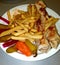 Arabic chicken shawarma dish with french fries and pickles