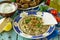 Arabic cuisine. Fresh homemade creamy mung hummus with spicy, falafel, sour cream sauce on a wooden kitchen table.