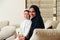 Arabic family, mother and son sitting on the couch in their living room