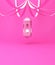 Arabic hanging lantern with ribbon on pink pastel background.