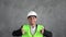 arabic male industrial engineer in uniform on grey background. Safety equipment. Young architect muslim man pointing