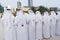 Arabic men standing in traditional cloth around modern buildings - Middle Eastern Culture - Emirati Men performing Al Ayala