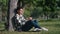 Arabic modern man use smartphone sitting near tree summer sunny park enjoy weekend outdoor leisure