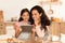 Arabic Mother And Daughter Using Tablet Baking Pastry In Kitchen