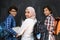 Arabic teenagers, students group portrait against black chalkboard wearing backpack and books in school.Selective focus