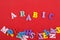 ARABIC word on red background composed from colorful abc alphabet block wooden letters, copy space for ad text. Learning