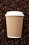 Arabica coffe aroma and takeout beverages concept with generic recyclable brown cardboard and paper cup with white plastic lid on