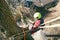 Arborist man cutting a branches with chainsaw and throw on a ground. The worker with helmet working at height on the trees. Lumber