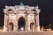 Arc de Triomphe on the Carrousel square near the Louvre museum at night, illuminated by lights and lanterns