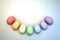 An Arc of Pastel Rainbow Colored 3D Illustrated Easter Eggs over a Bright Background.