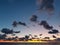 Arch of dramatic clouds in the sunset sky colored in blue, pink, yellow and orange, over the sea