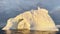 Arch in a huge iceberg, high breakaway glacier drifts in the southern ocean off the coast of Antarctica at sunset, the