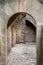 Arch of natural stone, leading to the courtyard with stone paving