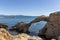 arch of portitxol on the costa brava with a tourist swimming a sunny summer day