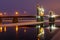 The arch of the Queen Louise Bridge is reflected in the night river Neman at sunset