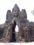 Arch with stone sculpted faces on a road in the Khmer temple complex of Angkor
