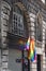 Arch windows of ancient building with hanging LGBTQ flags in Paris during pride. Transgender Pride flag