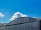 Arched aluminum clad corrugated metal hangar building. curving top detail. blue sky