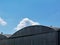 Arched aluminum clad hangar building top detail with blue sky