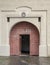 Arched  antique wooden door  with  black iron ornaments in a stone wall. Basilica Minor of Saint Benedict in Hronsky Benadik