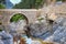 Arched bridge crossing rocky river in natural park in mountain region of Turkey.