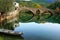 Arched bridge reflected in Crnojevica river, Montenegro