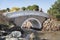 Arched concrete bridge over a river with white railing