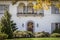 Arched door and upstairs balcony of elegant upscale stucco house with autumn wreath and leaves and pumpkin decorations