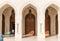 Arched gates and carved wooden doors leading to the Sultan Qaboos Grand Mosque, Oman, Middle East